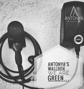 un caricabatterie usb collegato a un muro con un cartello di Antonya Apartments a Scena