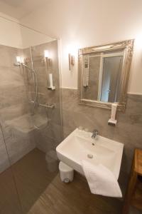a bathroom with a sink and a shower with a mirror at Hasseröder Burghotel in Wernigerode