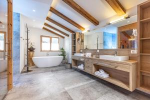uma casa de banho com uma banheira grande e um lavatório e uma banheira. em Das JUWEL Reith em Reith im Alpbachtal