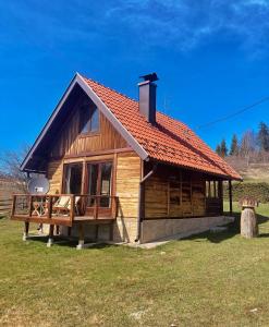a small wooden cabin with a red roof at Planinska Koliba Sekulić in Sekulić 
