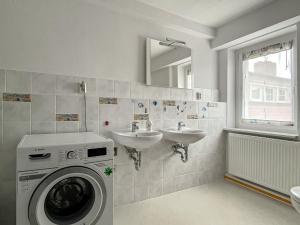 ein Badezimmer mit einer Waschmaschine und einem Waschbecken in der Unterkunft Apartment Fuchsbau in Senftenberg
