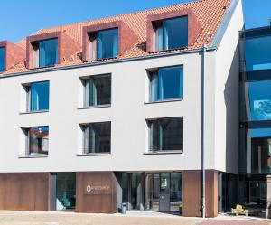 a white building with a red roof at Hotel Annenhof GmbH in Lemgo