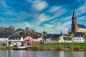 eine Stadt am Wasser mit einer Kirche in der Unterkunft Ferienhaus AM ALTEN POSTHOF in Lieser