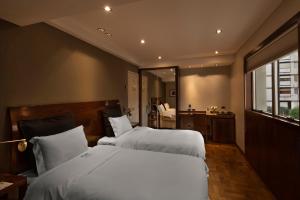 a bedroom with two beds and a large window at Windsor Hotel in Córdoba