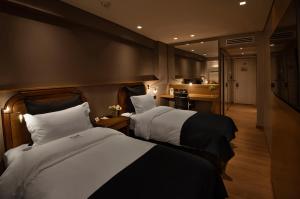 a hotel room with two beds and a kitchen at Windsor Hotel in Córdoba