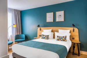 een slaapkamer met een groot bed met blauwe muren bij Appart'City Confort St Quentin en Yvelines - Bois D'Arcy in Bois-dʼArcy