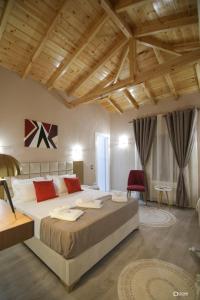 um quarto grande com uma cama grande e almofadas vermelhas em Vila Livi em Korçë