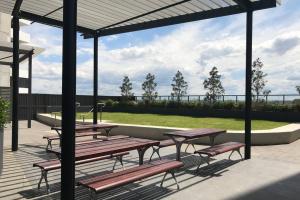 a group of picnic tables and benches under a pavilion at Liverpool holiday apartment 2Bedroom 2Bathroom in Liverpool