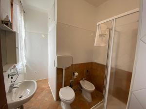 uma casa de banho com um WC, um lavatório e um chuveiro em Locanda della Pieve em Pievebovigliana