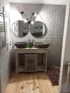 een badkamer met 2 spiegels en een wastafel bij chambre k au domaine du mont scolan in Montgardon