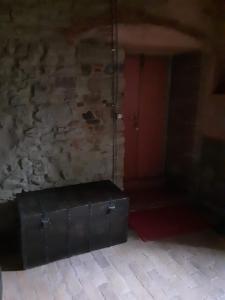 a room with a red door and a black trunk at B&B Il Castello in Castiglion Fibocchi