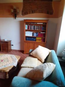 een woonkamer met een bank en een boekenplank bij B&B Il Castello in Castiglion Fibocchi