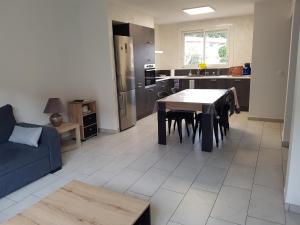 een keuken en een woonkamer met een tafel en een bank bij Maison - proche centre ville in Céret