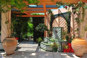 a garden with a pergola and some plants in pots at Villa Valflor chambres d'hôtes et appartements in Marseille