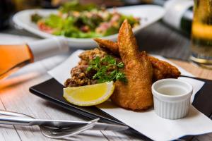 a plate of food with fried fish and a lemon at Nagasaki Chapel Coconuts Hotel ＆Resort in Isahaya