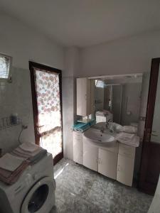 ein Badezimmer mit einer Waschmaschine und einem Waschbecken in der Unterkunft La Casa di Vitto in Boves