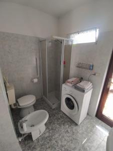 ein Badezimmer mit einer Waschmaschine und einem WC in der Unterkunft La Casa di Vitto in Boves