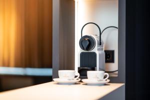 a coffee machine sitting on a counter with two cups at Villa Boutique Hotel in Straubing