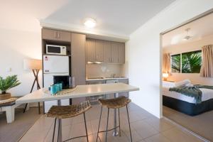 eine Küche und ein Wohnzimmer in einer Wohnung in der Unterkunft Waterlily - One Bedroom Apartment in Airlie Beach