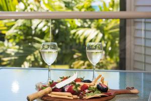 a plate of food and two glasses of wine at Waterlily - Two Bedroom Apartment in Airlie Beach