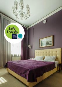 Schlafzimmer mit einem Bett mit lila Wänden und einem Kronleuchter in der Unterkunft Marel Hotel in Sankt Petersburg