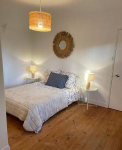 a bedroom with a bed with two tables and a mirror at Little Omaha in Vierville-sur-Mer