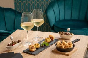 a table with two glasses of white wine and snacks at Sophie Terrace Hotel in Rome