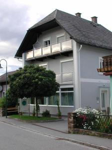 a white house with a balcony on a street at Ferienwohnung Maria in Großklein