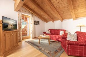 ein Wohnzimmer mit zwei roten Sofas und einem Tisch in der Unterkunft Wellnessappartements Margit in Alpbach