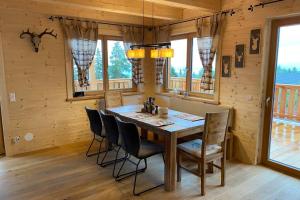 a dining room with a table and chairs and windows at Chalet am Skigebiet mit Sauna, Bar, Billard, Carport und Kinderspielzimmer in Bad Sankt Leonhard im Lavanttal