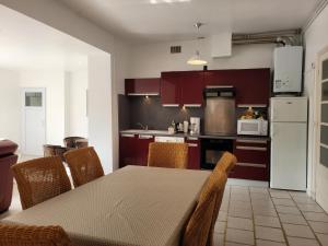 une cuisine avec une table avec des chaises et un réfrigérateur dans l'établissement l'echoppe rochelaise, à La Rochelle