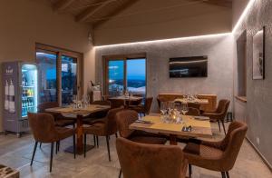 un comedor con mesas, sillas y ventanas en Sunstar Hotel Piemont, en Isola d'Asti