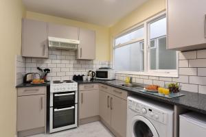 ダートマスにあるRiverside 1のキッチン(白いキャビネット、洗濯機、乾燥機付) +6枚の写真