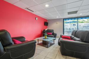 a waiting room with two leather chairs and a table at Appart'City Classic Saint-Nazaire Centre in Saint-Nazaire