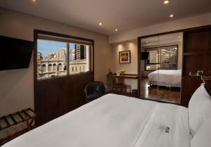 a hotel room with a bed and a large window at Windsor Hotel in Córdoba