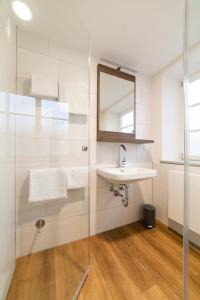 uma casa de banho com um lavatório e um espelho em Urban Flair Hotel em Memmingen