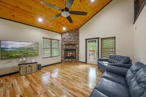 a living room with a ceiling fan and a fireplace at Smoky Mountain Chalet in Pigeon Forge