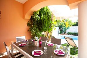 a dining room with a table and a pool at Casa Albufera in Playa de Muro