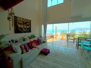 un soggiorno con divano e vista sull'oceano di Lofts do Morro Magico a Búzios