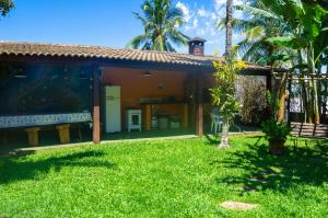 a house with a large aquarium in the yard at Casa Ilhabela - melhor custo benefício in Ilhabela