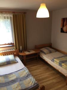 1 dormitorio con 2 camas, mesa y ventana en Agropensjonat Tramp z góralskim spa, en Żabnica