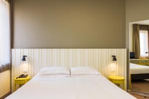 Un pat sau paturi într-o cameră la B&B Hotel Milano Ornato