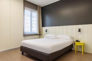 Un pat sau paturi într-o cameră la B&B Hotel Milano Ornato