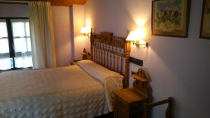 a bedroom with a bed and two lights on the wall at Casa Rómulo in Duruelo de la Sierra