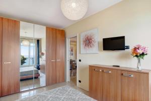salon z telewizorem i wazą kwiatów w obiekcie Casa Miradore 600 mt dal mare w mieście Imperia