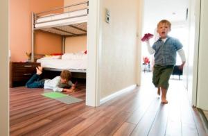 2 Kinder spielen in einem Schlafzimmer mit Etagenbett in der Unterkunft ancora Marina Haus 1 Nr 03, Typ 1 in Neustadt in Holstein