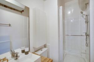 a white bathroom with a shower and a sink at Le Black and White - Trianon in Versailles +11 photos