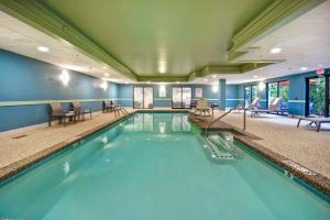 una piscina con sedie e tavoli in un edificio di Holiday Inn Express Newport North - Middletown, an IHG Hotel a Middletown