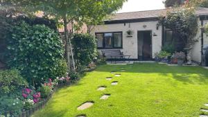 a backyard with a lawn with rocks in the yard at The Coach House in Bewdley