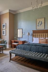 um quarto com uma cama grande e uma cadeira em Rockliffe Hall Hotel Golf & Spa em Darlington